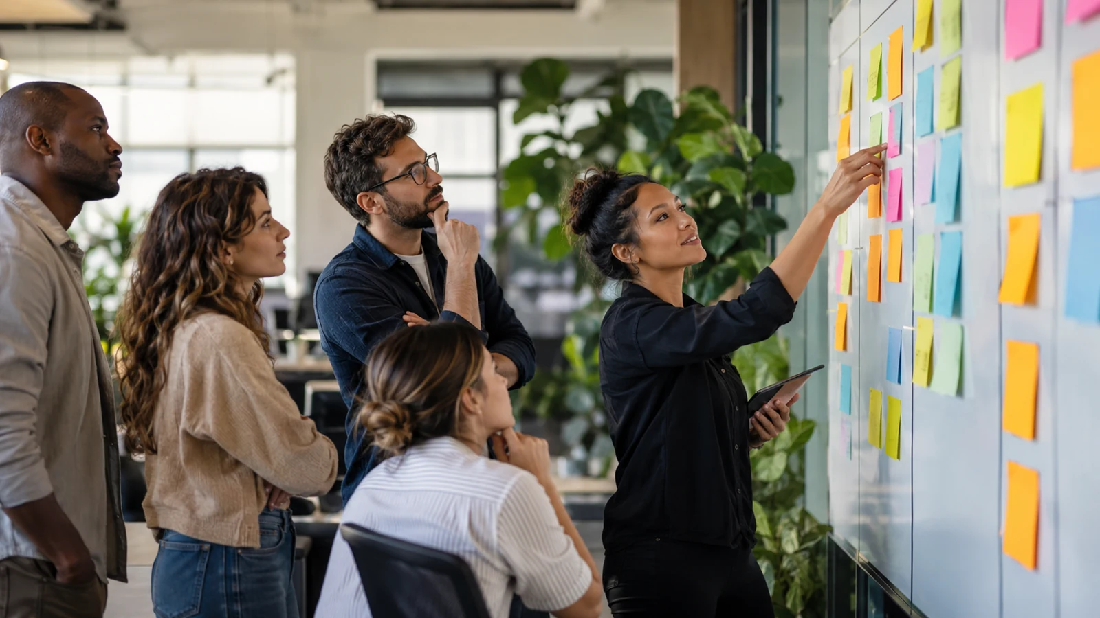 Editorial image of a support team reviewing a wall of color-coded requests with no visible customer data or readable labels.
